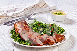 Roast Pork Tenderloin with kale salad on plate