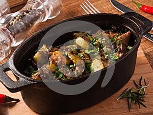 Roast in a pot with pickles, cucumbers and potatoes on a wooden Board