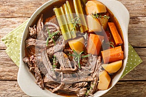Roast pot of slow cooked beef with vegetables in a spicy sauce close-up in a frying pan. horizontal top view photo