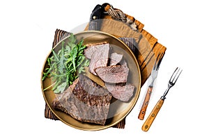 Roast Tri Tip or sirloin bottom beef steak on a plate with arugula. Isolated, white background.