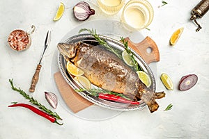 Roasted arctic char with lemon on plate. Delicious baked fish on a light background, banner, menu, recipe place for text, top view