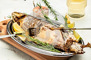 Roasted arctic char with lemon on plate. Delicious baked fish on a light background, banner, menu, recipe place for text, top view