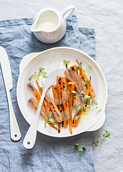 Roasted baby carrots and greek yogurt. On a light background