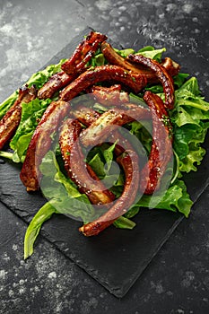 Roasted barbecue hot pork ribs served on stone board with vegetable