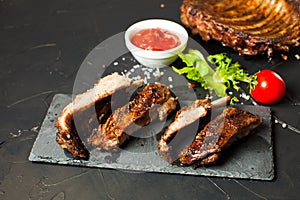 Roasted barbecue pork ribs on the black