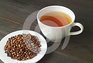Roasted Barley with a Cup of Hot Japanese Barley Tea or Mugicha on Black Wooden Table
