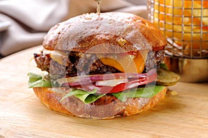 Roasted beef hamburger with cheese and vegetables close-up