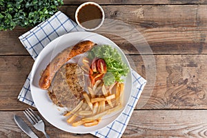 Roasted beef meat steak and sausage with french fries.