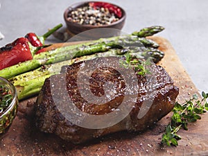 Roasted beef steak, mutton with asparagus pepper on a cutting board close up