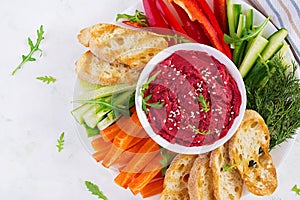 Roasted beet hummus with toast and vegetables. Beetroot hummus.