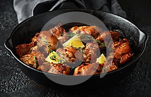 Roasted boneless skinless chicken thighs in lemon and thyme dressing served in vintage cast iron skillet, frying pan photo