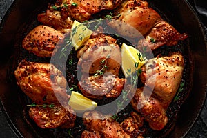 Roasted boneless skinless chicken thighs in lemon and thyme dressing served in vintage cast iron skillet, frying pan