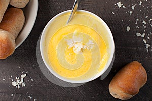 Roasted Butternut Squash Soup on dark background with rolls