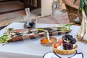 Roasted Calcots onions served on plate with Romesco sauce â€“ traditional Catalan winter dish