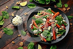 Roasted carrot salad with feta cheese, walnut and spinach. healthy food