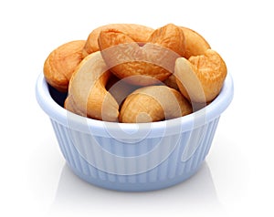 Roasted cashew nuts in a bowl on white background