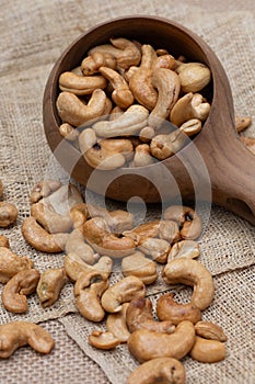 Roasted cashew nuts and halves in wooden bowl on table top view. Macro studio shot Homemade Roasted Salted Cashews in basket and