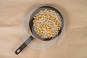 Roasted cashews in frying pan on paper