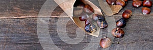 Roasted chestnuts  in a papaer bag  on wooden table