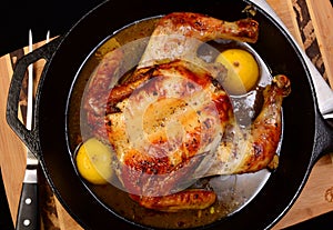 Roasted chicken in a cast iron skillet with lemon