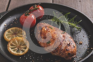 Roasted chicken fillet breast with lemon tomato rosemary on a frying pan