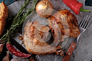 Roasted chicken leg and wing with chili on a wooden table