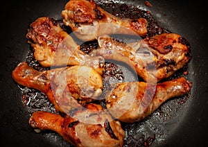 Roasted chicken legs in a black pan