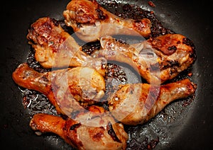 Roasted chicken legs in a black pan photo