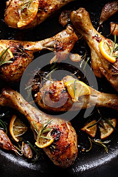 Roasted chicken legs with rosemary, garlic and lemon in a cast iron skillet