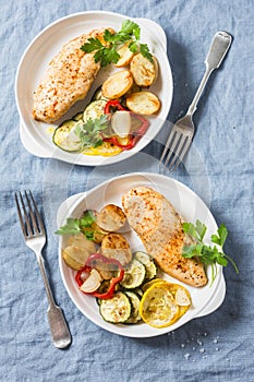 Roasted chicken provencal with zucchini, squash, potatoes. Delicious healthy lunch on a blue background,
