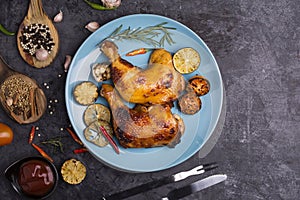 Roasted chicken and rosemary lemon and tomato are arranged in a delightful blue plate Ready to serve with spices and sauce Placed