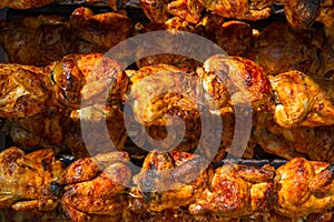 Roasted chicken in a row turning on a roaster