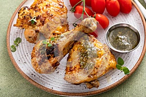Roasted chicken thighs and drumsticks served with pesto sauce