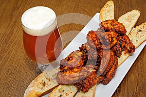 Roasted chicken wings and glass of beer