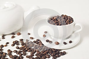 Roasted coffee bean in a cup against white background