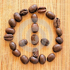 Roasted coffee beans arranged in peace sign for backdrops, backgrounds, and banners.