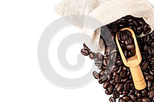 Roasted coffee beans in bag with old scoop isolated on white background.