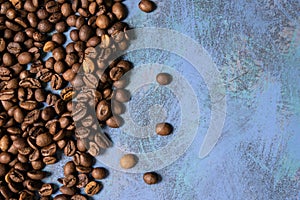 Roasted coffee beans in bulk on a blue background. dark cofee roasted grain flavor aroma cafe, natural coffe shop background, top