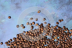 Roasted coffee beans in bulk on a blue background. dark cofee roasted grain flavor aroma cafe, natural coffe shop background, top