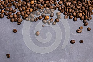 Roasted coffee beans in bulk on a gray concrete background. dark cofee roasted grain flavor aroma cafe, natural coffe shop