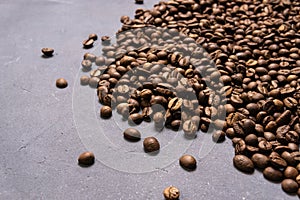 Roasted coffee beans in bulk on a gray concrete background. dark cofee roasted grain flavor aroma cafe, natural coffe shop