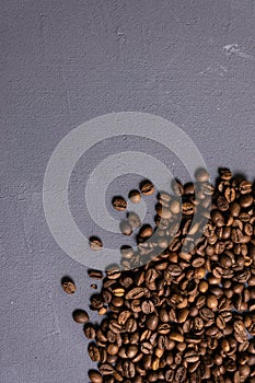 Roasted coffee beans in bulk on a gray concrete background. dark cofee roasted grain flavor aroma cafe, natural coffe shop