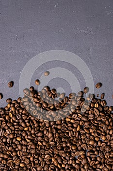 Roasted coffee beans in bulk on a gray concrete background. dark cofee roasted grain flavor aroma cafe, natural coffe shop