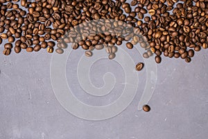 Roasted coffee beans in bulk on a gray concrete background. dark cofee roasted grain flavor aroma cafe, natural coffe shop