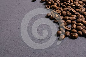 Roasted coffee beans in bulk on a gray concrete background. dark cofee roasted grain flavor aroma cafe, natural coffe shop