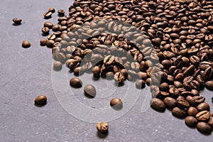 Roasted coffee beans in bulk on a gray concrete background. dark cofee roasted grain flavor aroma cafe, natural coffe shop