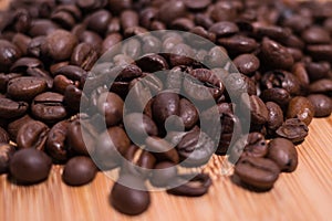 Roasted Coffee Beans close up / macro view on natural wooden background