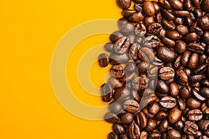 Roasted coffee beans close up. Yellow background. Space for text