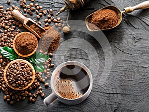 Roasted coffee beans, coffee cup  and ground coffee on wooden table. Top view