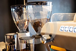 Roasted coffee beans in coffee grinder preparing to grind coffee,profession electric grinder in cafe shop